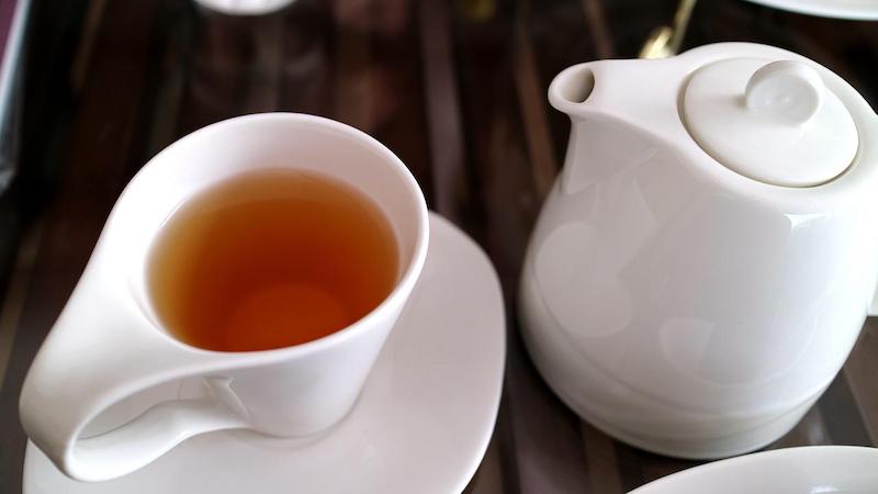 紅茶の入った白いティーカップとティーポット